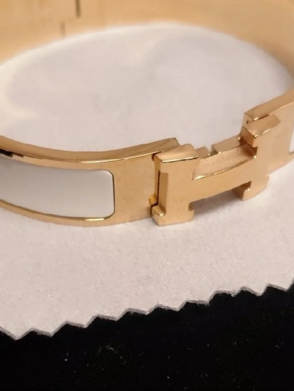 HERMES Gold and White Enamel Click H Bracelet with Signature H Accent.